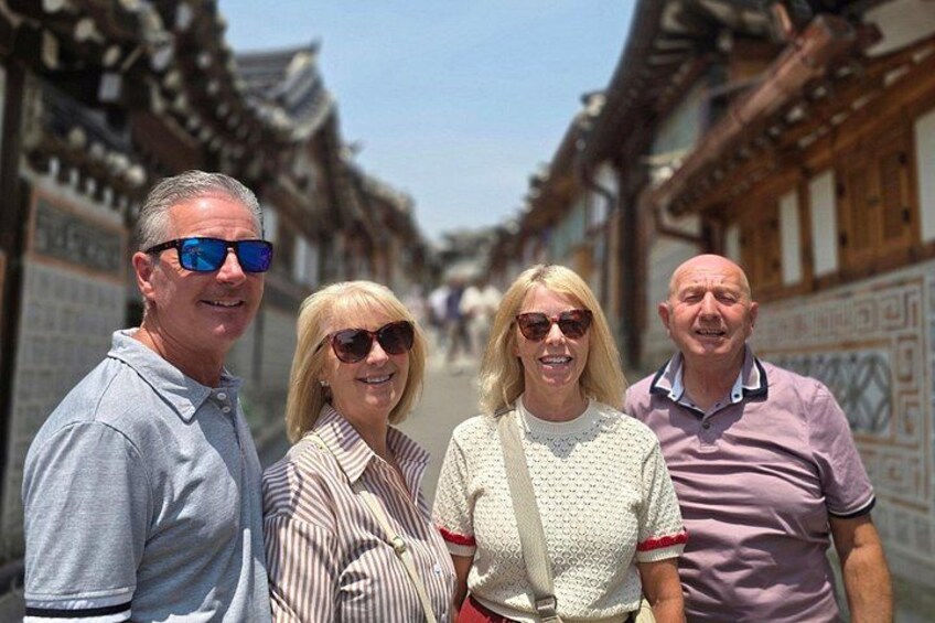 A group of people standing in front of traditional architecture. 1