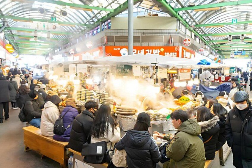 A busy indoor market with people shopping and eating. 5