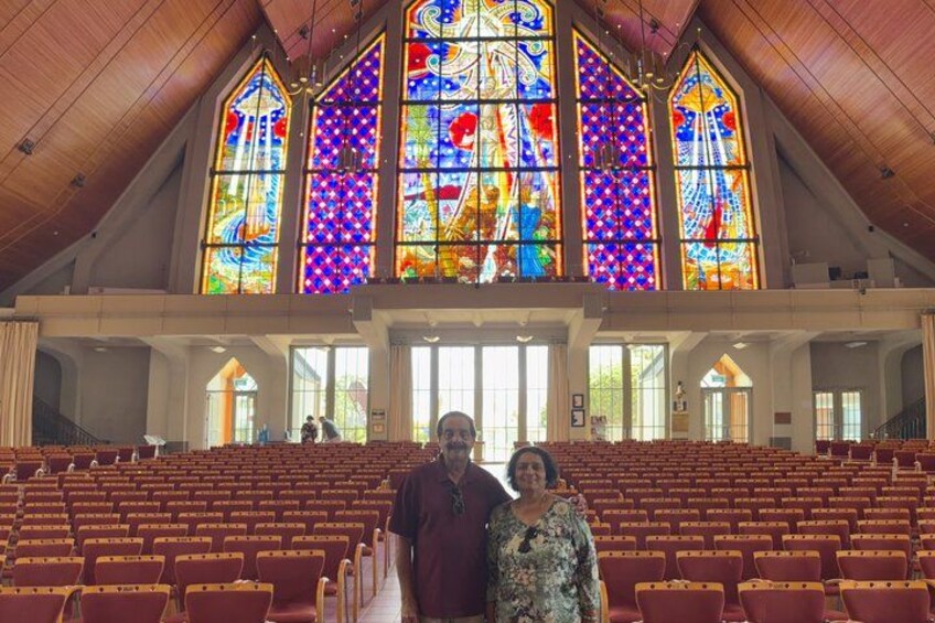 L’intérieur d’une église, avec ses vitraux et ses rangées de bancs. 4