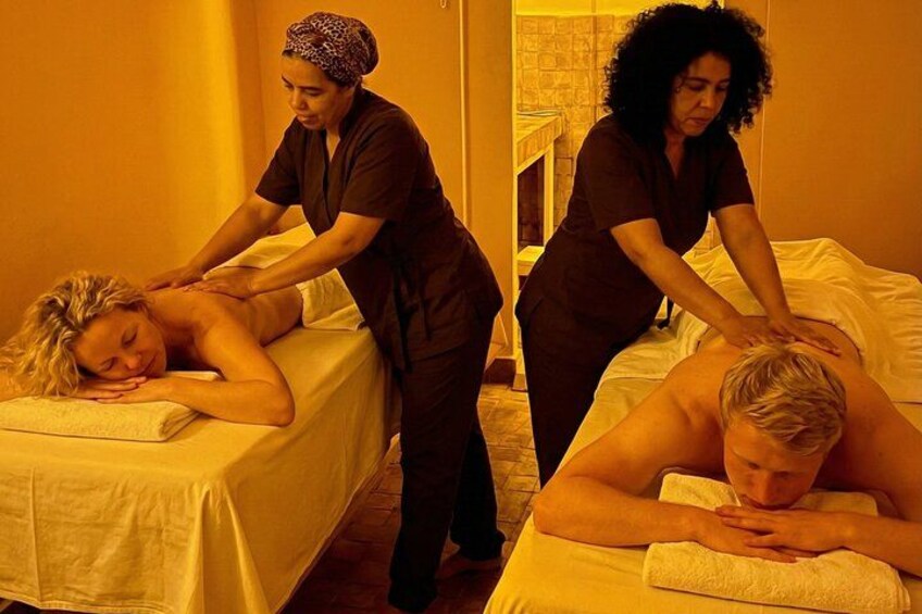 A massage therapy session with two clients receiving treatment. 2