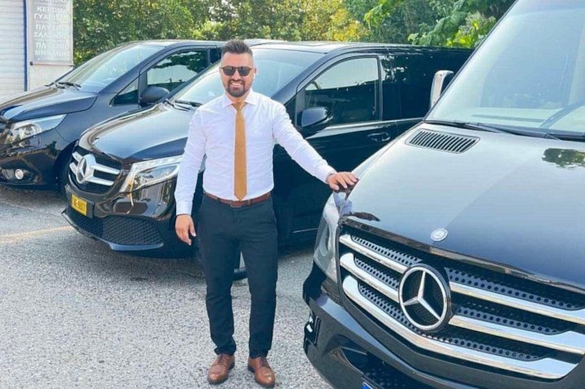 En person står ved siden af en sort Mercedes-Benz SUV på en parkeringsplads. 1
