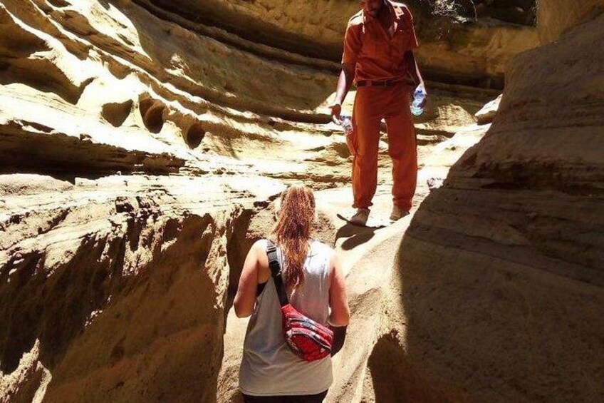 A person walking through a narrow canyon with steep walls. 3