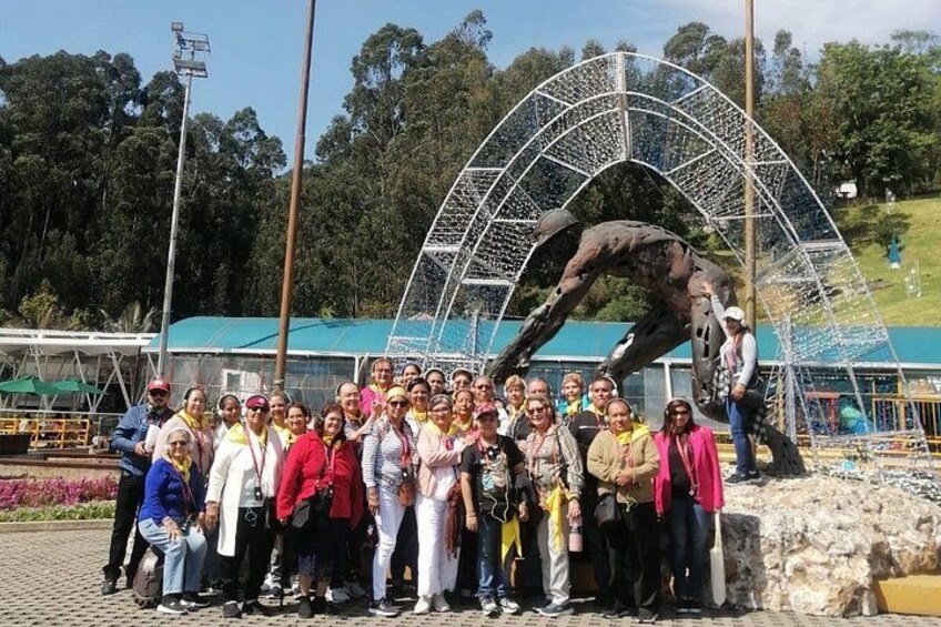 A group of people posing in front of a large metal sculpture of a horse. 4