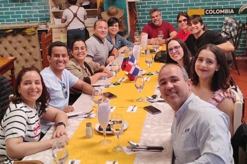 A group of people dining at a restaurant with a yellow tablecloth and a flag. 3