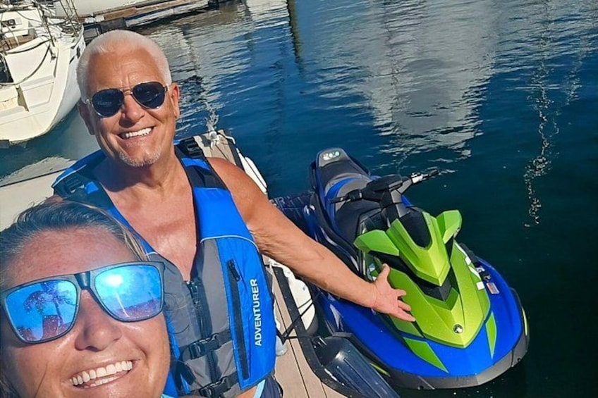 Deux personnes sur un jet ski, une étendue d’eau et un quai avec des bateaux. 2