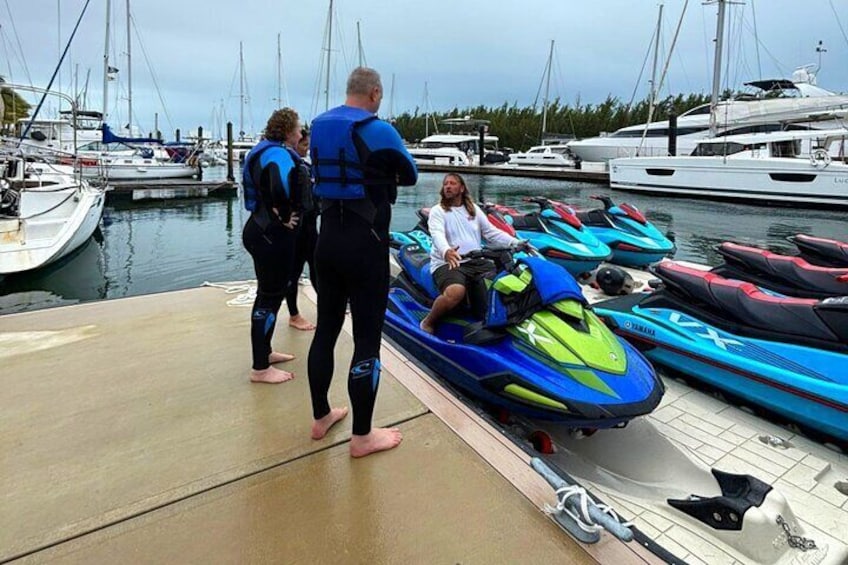 Folk ved en lysthavn med jetski og både. 5