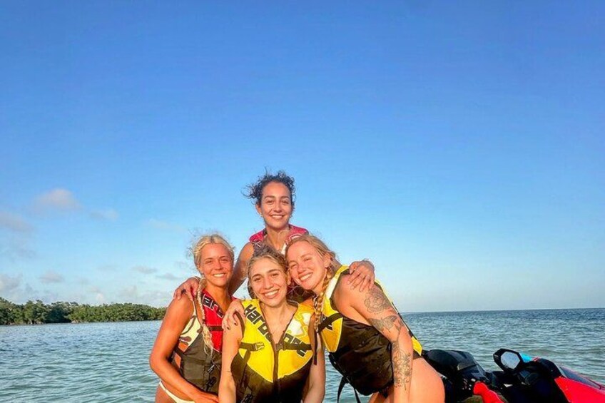 A group of people on a boat with water and a clear sky in the background. 1