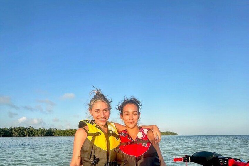 Dos personas en un bote, con agua y una masa de tierra a lo lejos. 2