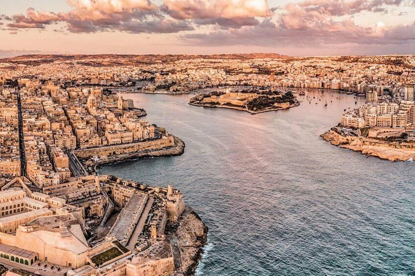 A coastal cityscape with a prominent harbor, historic buildings, and a fortified wall. 4