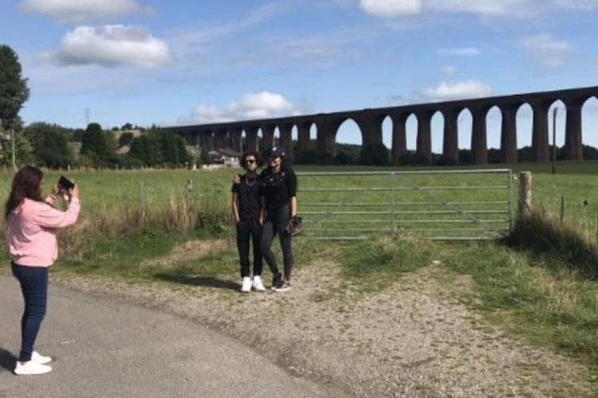 En viadukt, en græsmark og en person der tager et billede. 3