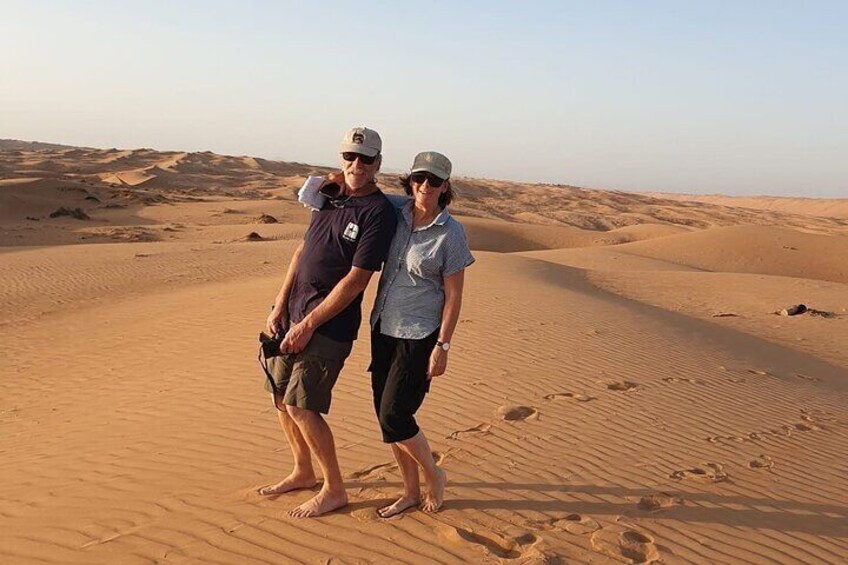 Zwei Personen stehen auf einer Sanddüne in einer Wüstenlandschaft. 2