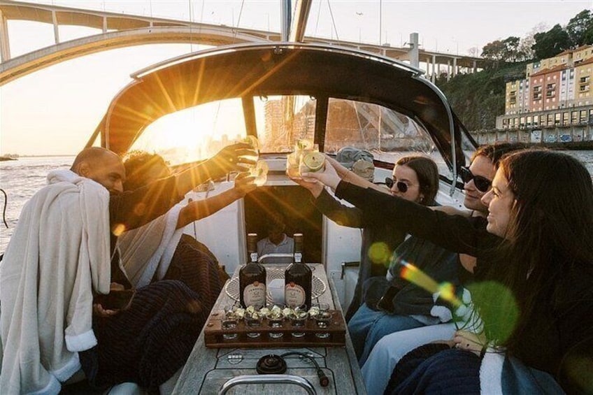 Een groep mensen die aan het proosten is op een boot, met flessen en glazen op het dek. 2