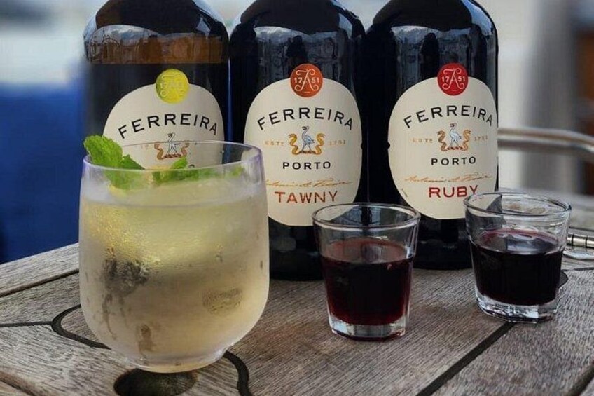Tre flasker FERREIRA Porto Tawny og Ruby vin, et glas med en lysemættet drik og mynte, samt to glas fyldt med Ruby vin. 2