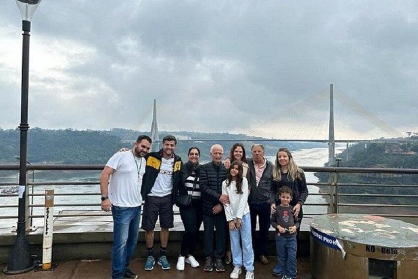 Un grupo de personas posando sobre un puente con una estructura atirantada de fondo. 4