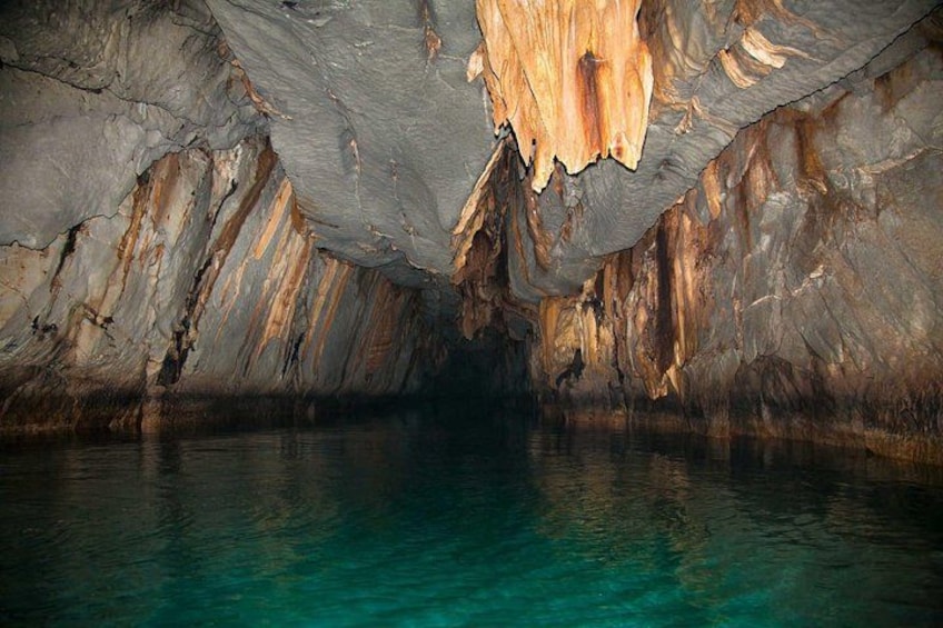 L’intérieur d’une grotte, avec des stalactites et des stalagmites, et une étendue d’eau. 2