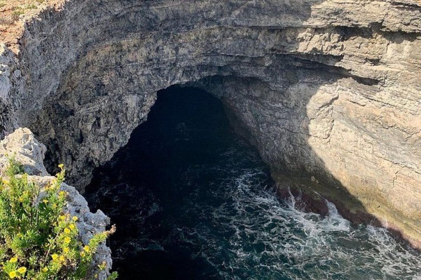 Formazione rocciosa costiera con un arco naturale sul mare. 4