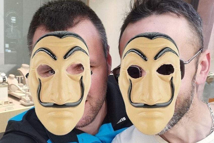 Two individuals wearing masks with a blue and white background. 2