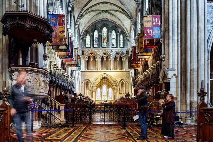 A cathedral interior with a high arched ceiling, stained glass windows, and a central altar. 2