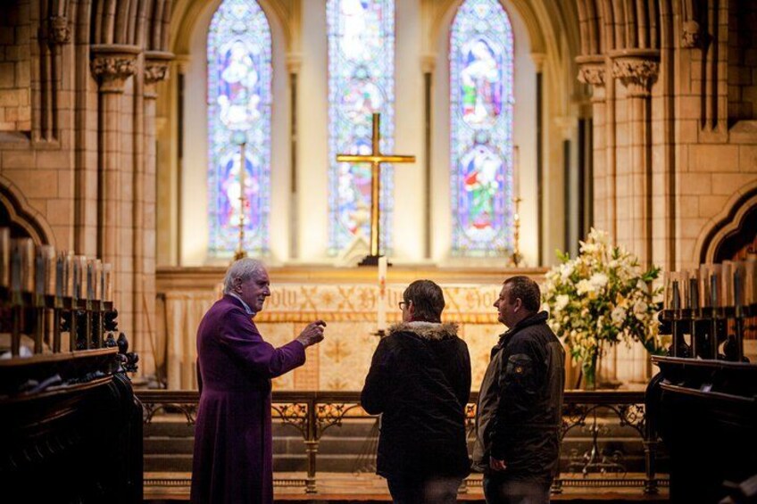 A church interior with stained glass windows and a cross. 2