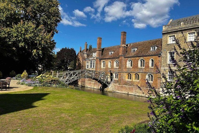 A historic building with a brick facade, a stone bridge, and a well-maintained lawn. 1