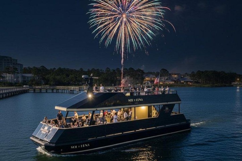 Un barco llamado 'SOVILNA' en el agua con fuegos artificiales al fondo. 2