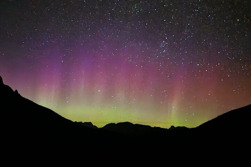 A night sky with the aurora borealis over a mountainous landscape. 2