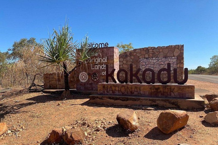 A sign for Kakadu National Park with a desert landscape in the background. 4