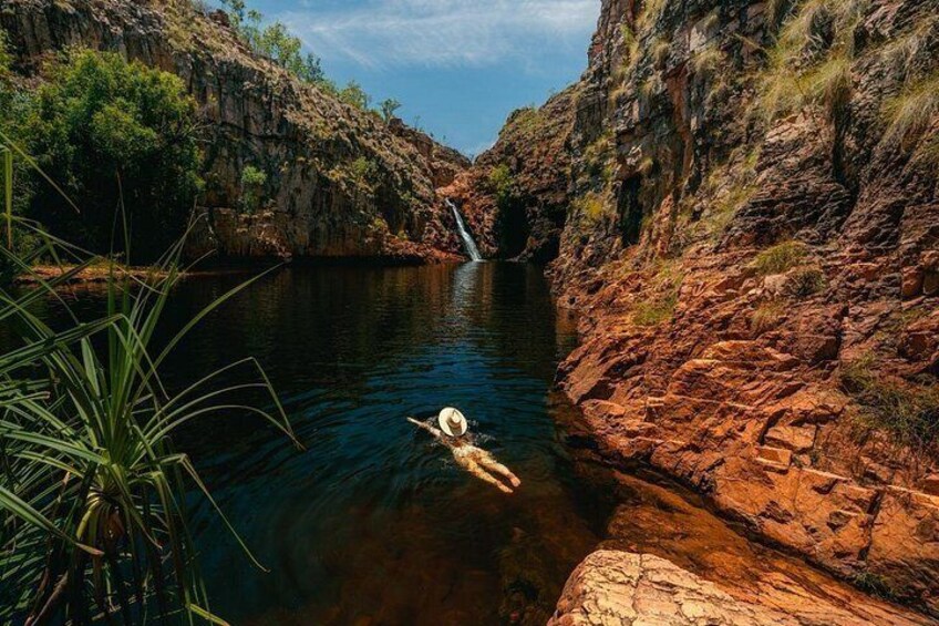 A person swimming in a river surrounded by rocky cliffs. 3