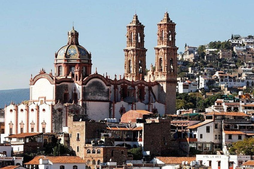 A historic church with two bell towers, surrounded by residential buildings. 1