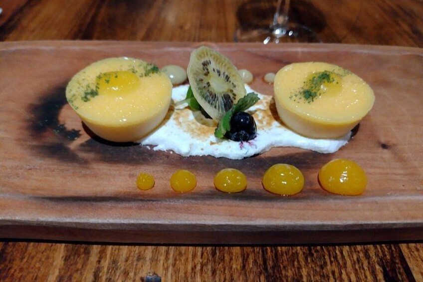 Un postre con rodajas de kiwi, arándanos y una cobertura cremosa sobre una tabla de madera. 4