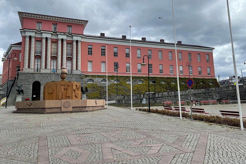 A pink building with a fountain in front. 2