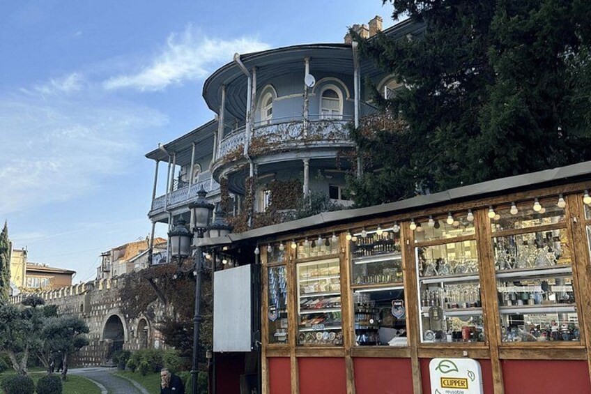 Un edificio storico con un balcone, un negozio con vetrine e un cielo sereno. 4