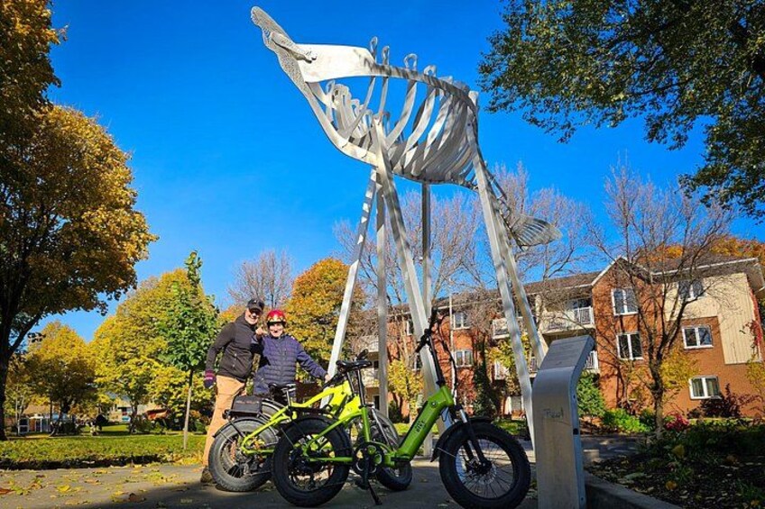 A sculpture of a sailboat, a green bicycle, and a person with a helmet. 5