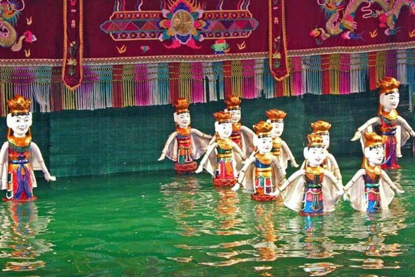 Un grupo de artistas con trajes tradicionales en un escenario con un decorado colorido. 2