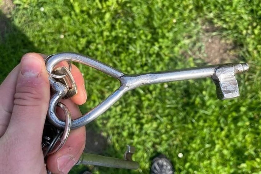 A hand holding a metal tool with a long handle and a pointed end. 5