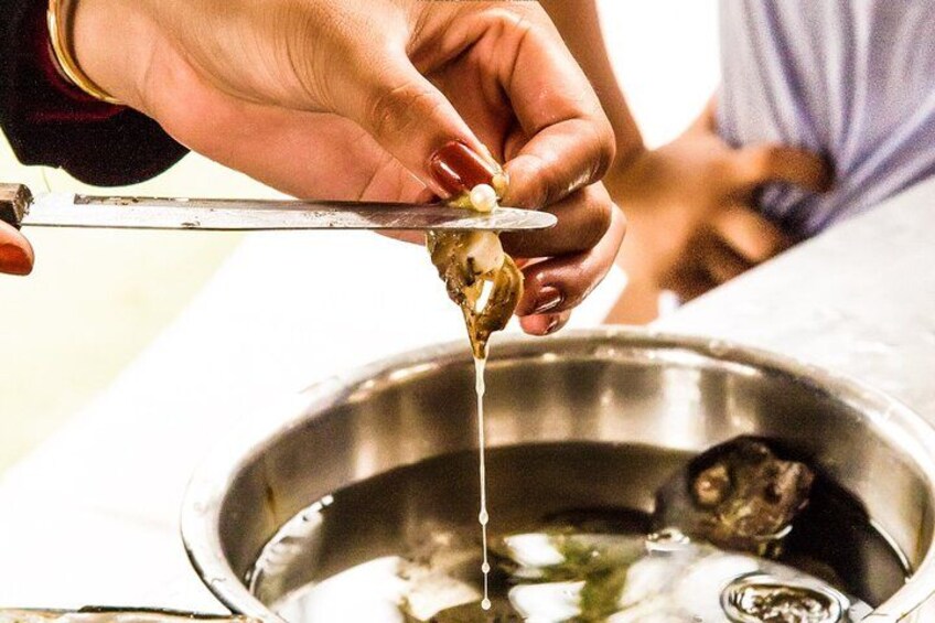 Une personne qui découpe un aliment avec un couteau, un bol en métal étant placé en dessous. 2
