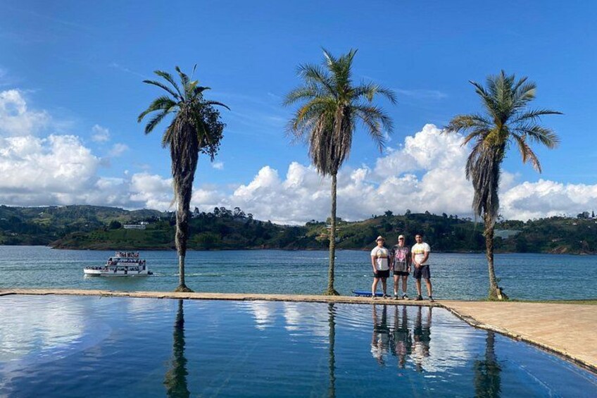A swimming pool with palm trees and a boat on the water. 1