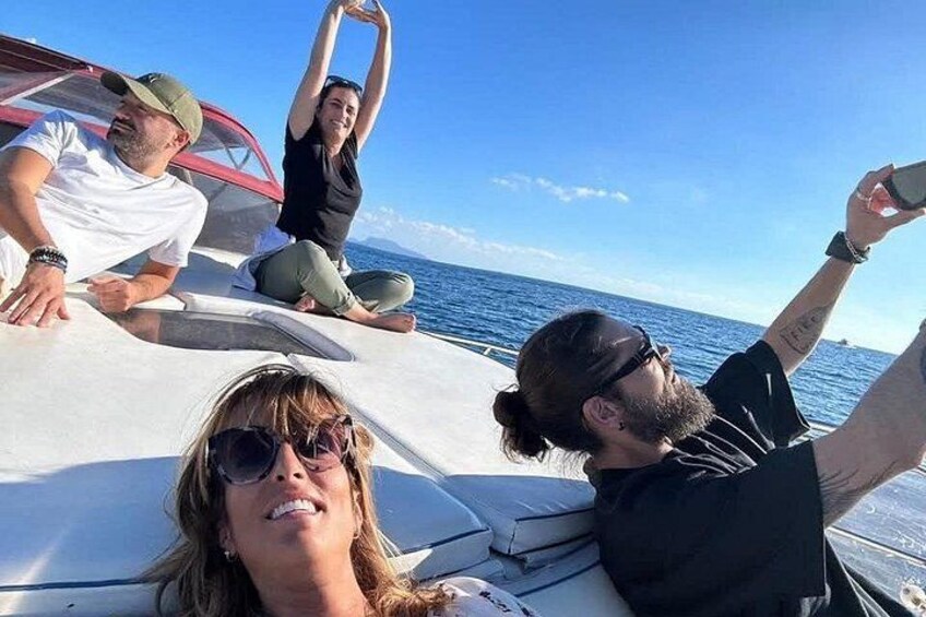 A group of people on a boat with the ocean and a clear sky in the background. 1