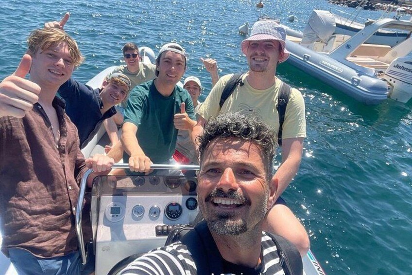 A group of people on a boat with a water body and another boat in the background. 4