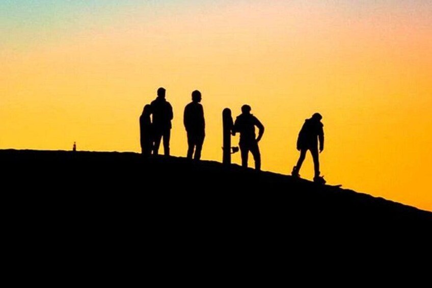 Silhouetten van mensen op een heuvel tijdens de zonsondergang. 5