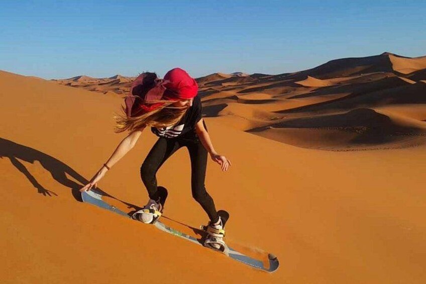 Iemand snowboardt over een zandduin. 4