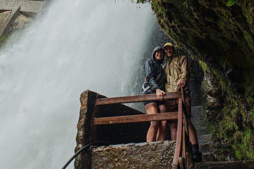 Zwei Personen sitzen auf einer Holzbank neben einem Wasserfall. 2