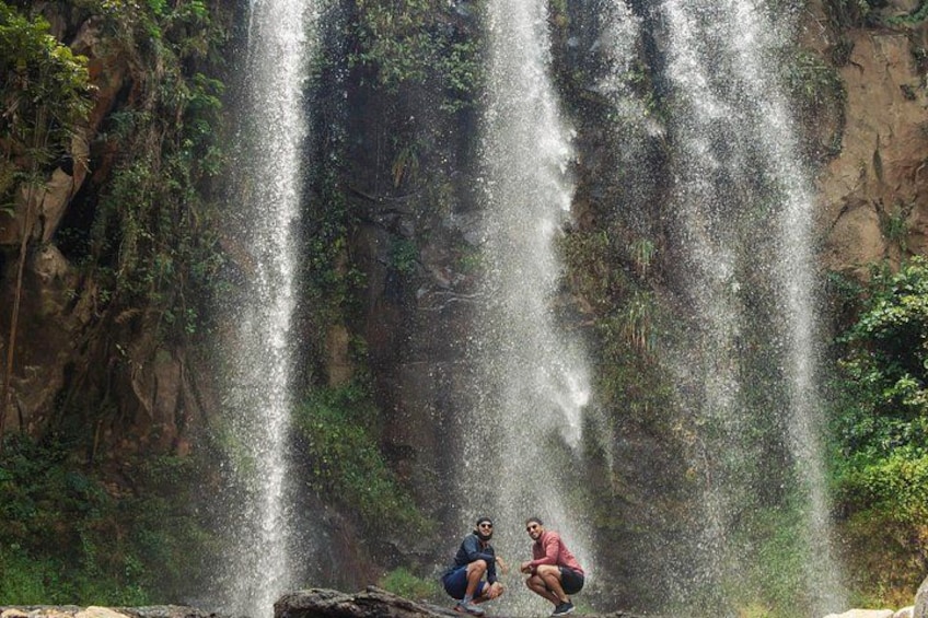 Ein Wasserfall mit mehreren Rinnsalen, umgeben von viel Grün und felsigen Klippen. 3