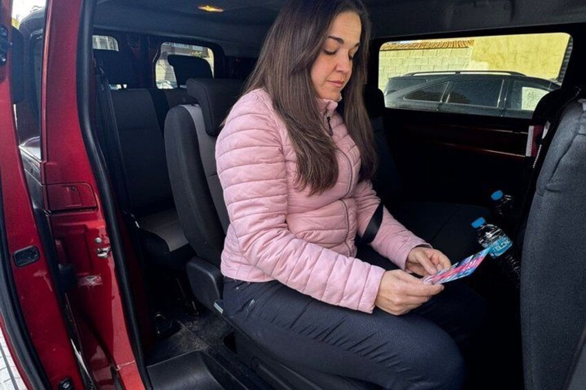 Una persona sentada en un coche rojo, sosteniendo un mapa. 4