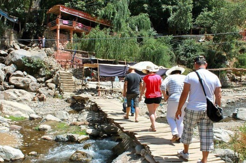 A wooden bridge over a stream, surrounded by rocks and greenery. 5