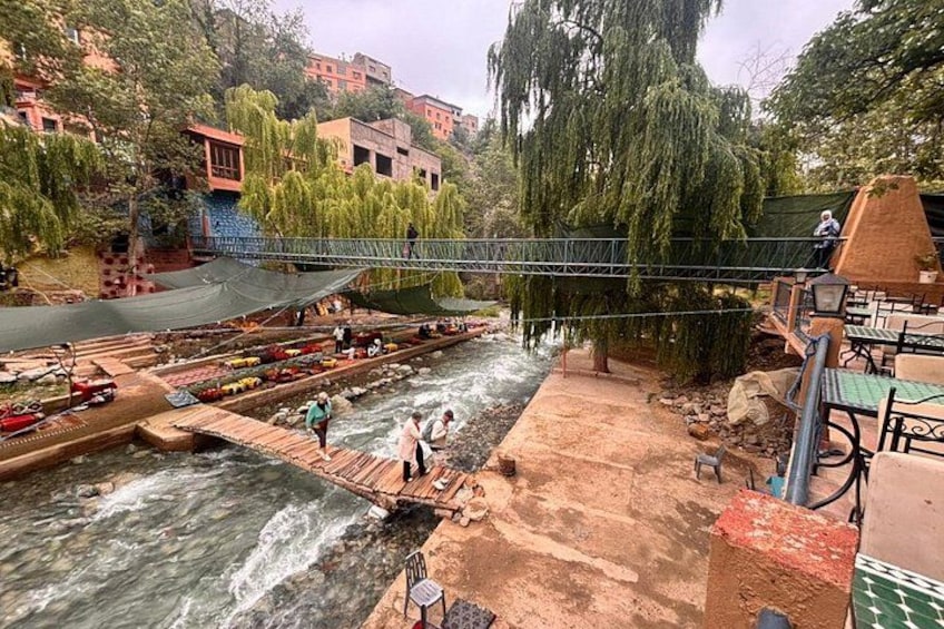 A river with boats, a bridge, and people walking. 3