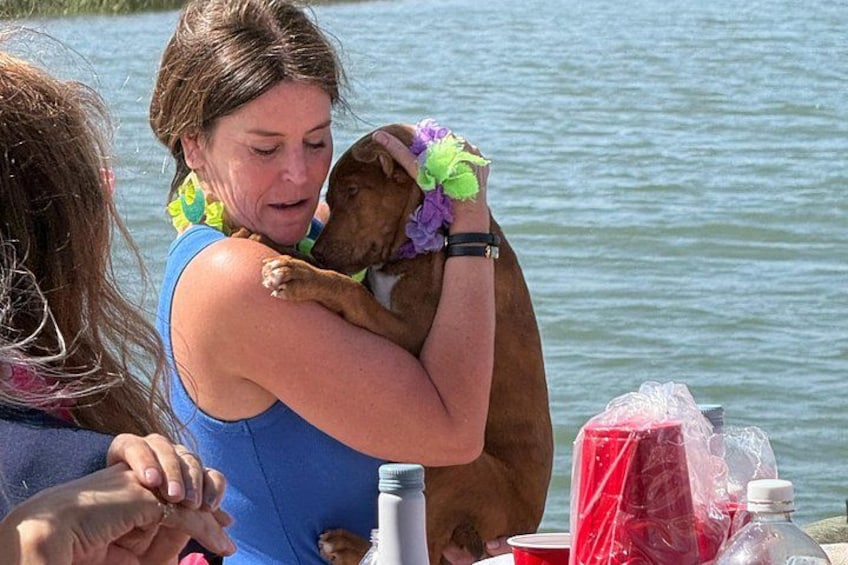 A person holding a dog by a lake. 4