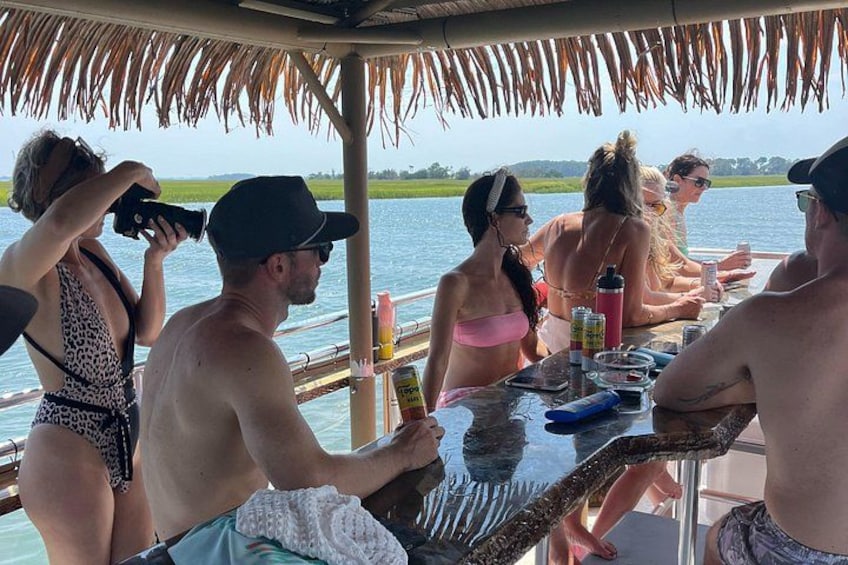 Un grupo de personas en un bote con techo de paja, rodeado de agua y vegetación. 5
