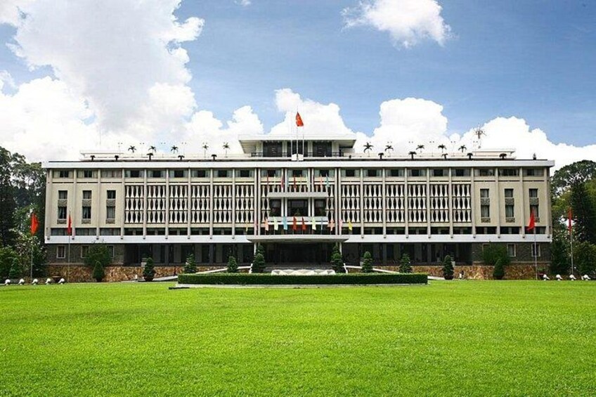 A large, modern building with a symmetrical facade, a central entrance, and a well-maintained lawn in front. 1