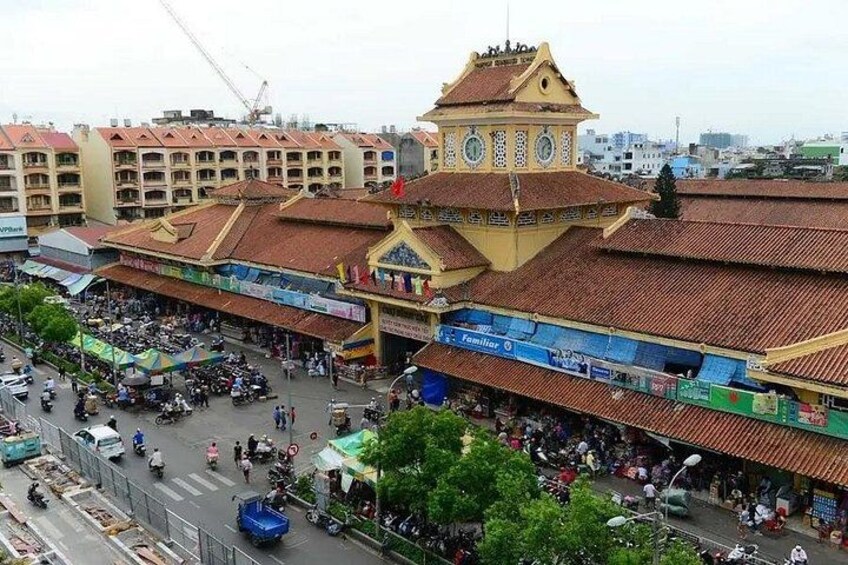 A busy market area with a prominent clock tower, surrounded by various shops and stalls. 2